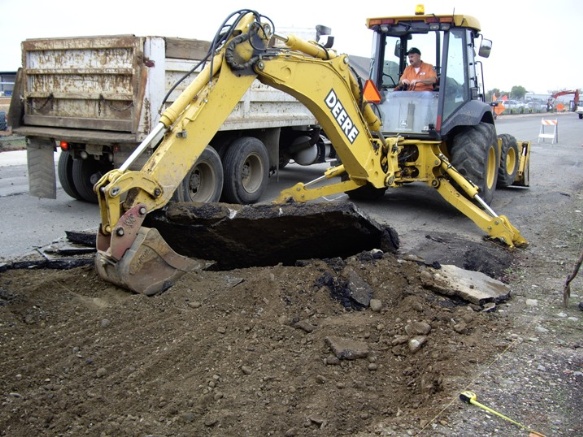 backhoe tearing up the street